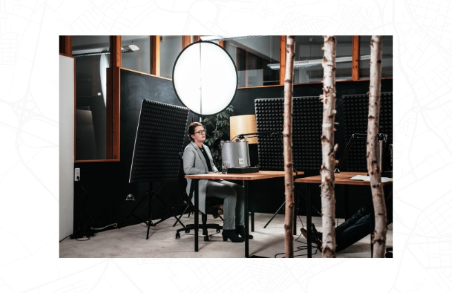 Podcast-Aufnahme in einem Studio mit Sprecherin, Mikrofon und Akustikelementen