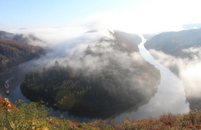 Luftbild der Saarschleife mit bewaldeten Hängen, Flussschleife und Nebel
